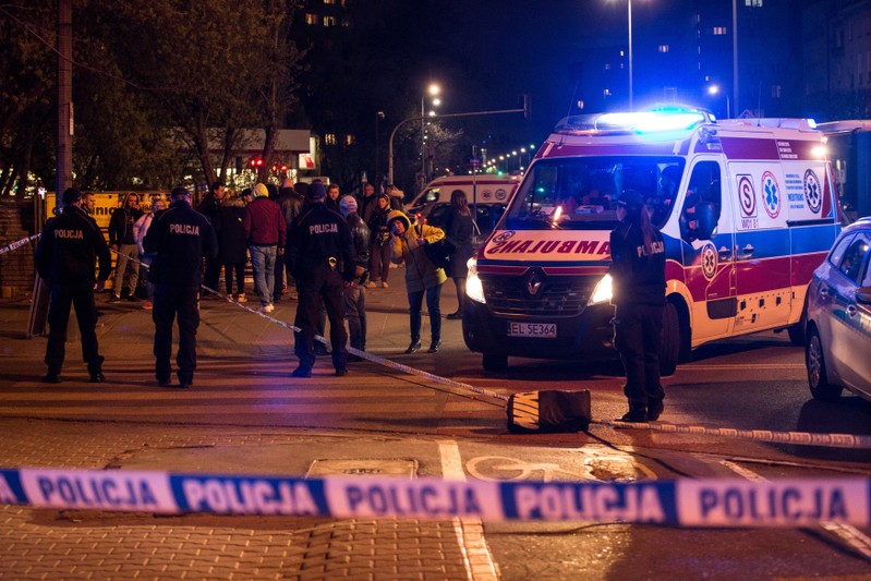 Police officers investigate the site of stabbing in Warsaw