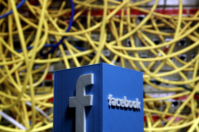 FILE PHOTO: A 3D plastic representation of the Facebook logo is seen in front of displayed cables in this illustration in Zenica