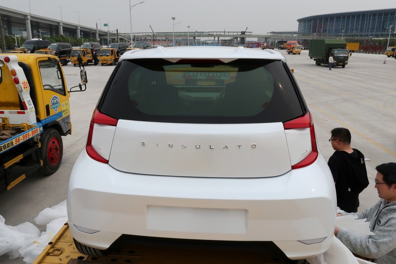 Singulato workers unwrap a concept car in preparation for the auto show in Shanghai