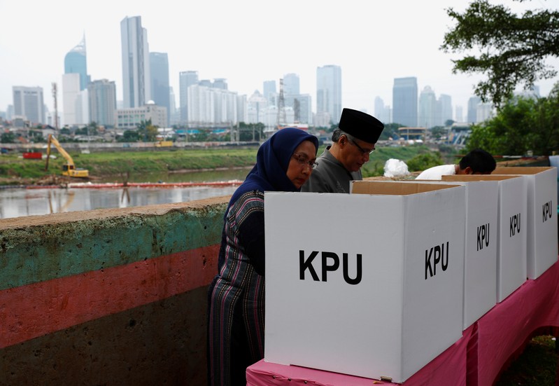 Voters mark their ballots at a polling centre during elections in Jakarta, Indonesia