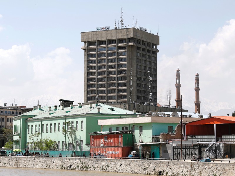 Men carry injured people outside the Ministry of Communication and Information Technology in Kabul