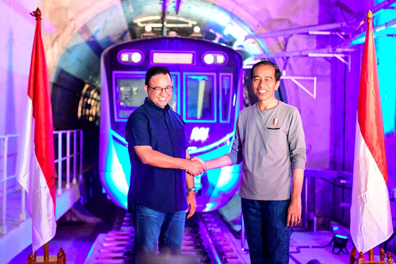 FILE PHOTO - Indonesia's President Joko Widodo (R) shakes hands with Governor of Jakarta Anies Baswedan (L) during Jakarta Mass Rapid Transit (MRT) first-phase launching at Bundaran HI station in Jakarta