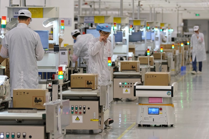 FILE PHOTO: Employees work on a mobile phone production line at Huawei's factory campus in Dongguan, Guangdong province