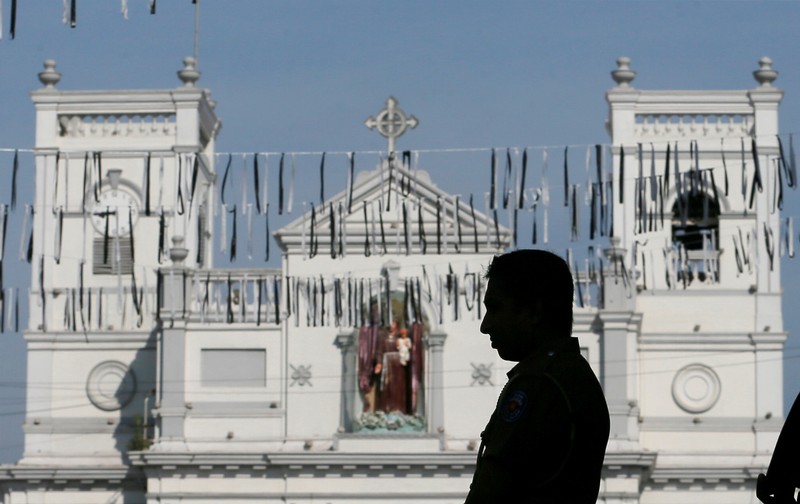 A security personnel observes three minutes of silence as a tribute to victims, two days after a string of suicide bomb attacks on churches and luxury hotels across the island on Easter Sunday, near St Anthony Shrine in Colombo