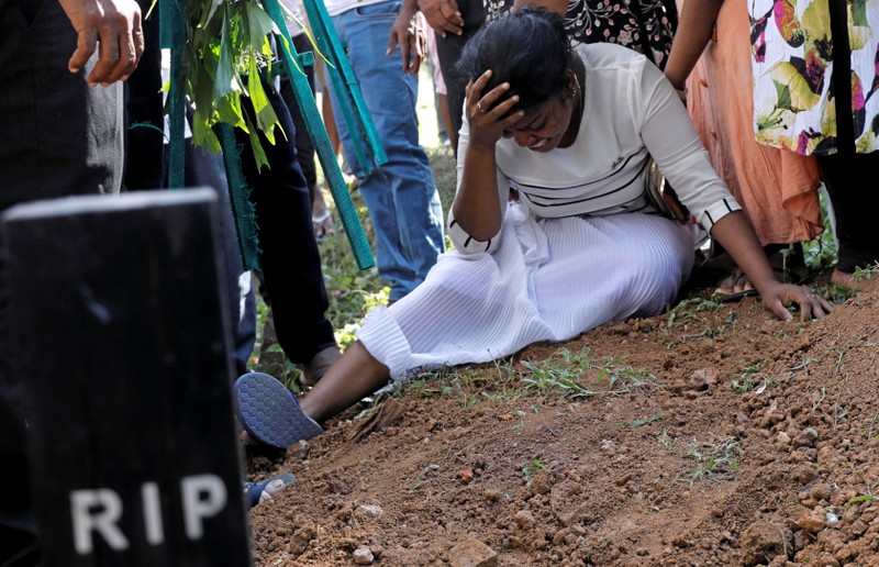 A woman reacts during a mass burial of victims, two days after a string of suicide bomb attacks on churches and luxury hotels across the island on Easter Sunday, in Colombo