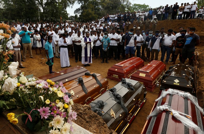 People participate in a mass funeral in Negombo