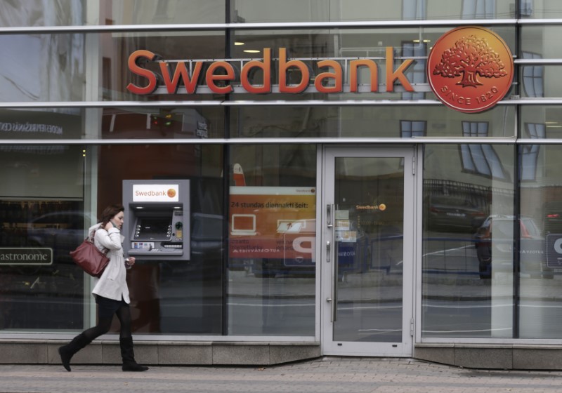 FILE PHOTO: A woman walks past Swedbank branch in Riga
