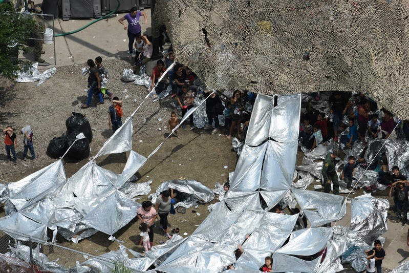 Migrants are seen outside the U.S. Border Patrol McAllen Station in a makeshift encampment in McAllen