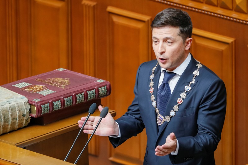 Ukraine's new President Volodymyr Zelenskiy applauds after taking the oath of office during his inauguration ceremony in the parliament hall in Kiev