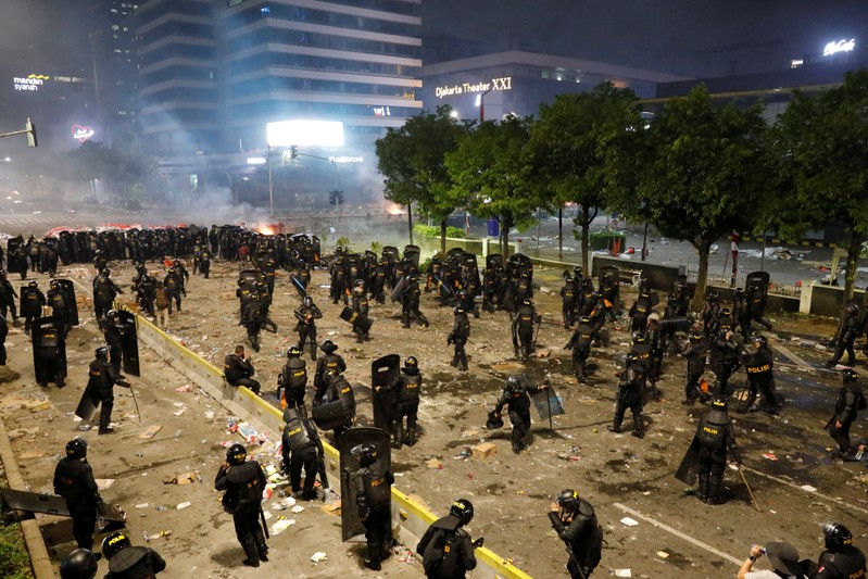 Riot police officers guard during a riot near the Election Supervisory Agency (Bawaslu) headquarters in Jakarta