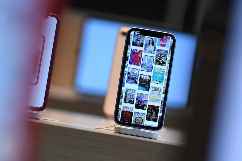FILE PHOTO: Front pages of newspapers and magazines are displayed on an iPhone during the grand opening and media preview of the new Apple Carnegie Library store in Washington