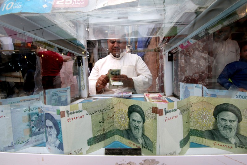 FILE PHOTO: A man counts Iranian rials at a currency exchange shop, before the start of the U.S. sanctions on Tehran, in Basra