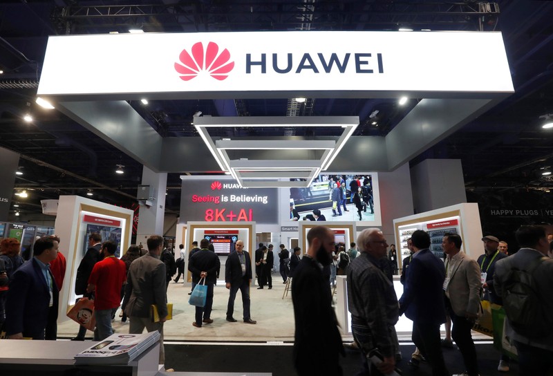 Participants pass by a Huawei booth at CES 2019 in Las Vegas.