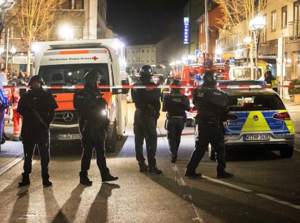 Police stand guard near the scene of a shooting in central Hanau Germany Thursday Feb. 20 2020