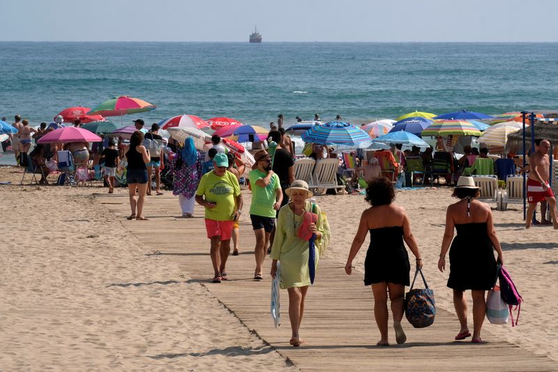 FILE PHOTO: Beachgoers gather on the eastern coast to enjoy the last days of the summer season in Gandia near Valencia