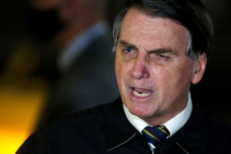 FILE PHOTO: FILE PHOTO: Brazil's President Jair Bolsonaro speaks with journalists as he arrives at Alvorada Palace, amid the coronavirus disease (COVID-19) outbreak, in Brasilia