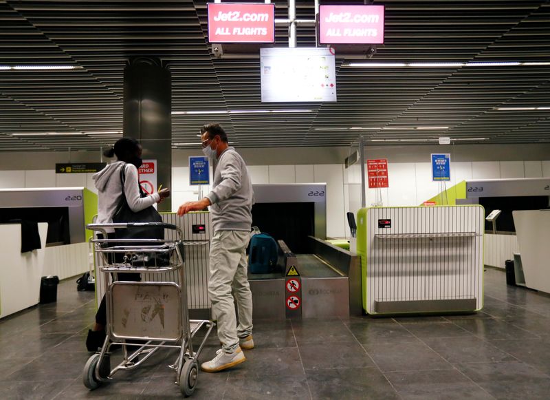 FILE PHOTO: British tourists returning to UK, check in their luggage, as Britain imposed a two-week quarantine on all travellers arriving from Spain